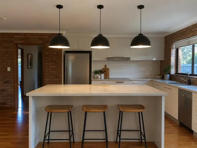 Three black pendant lights above a kitchen island in a brick and white kitchen in Bella Vista